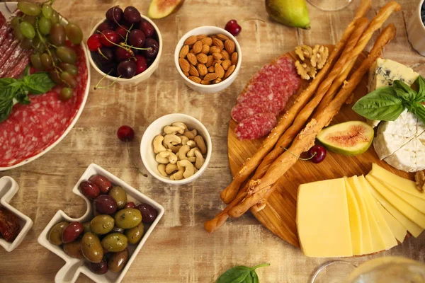 Abendessen mit Snacks und Weingläsern auf dem Tisch im Wohnzimmer — Stockfoto