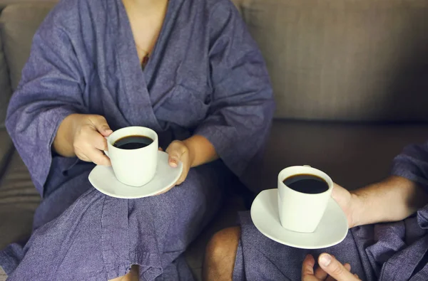 Pareja cariñosa en albornoz tomando café por la mañana — Foto de Stock
