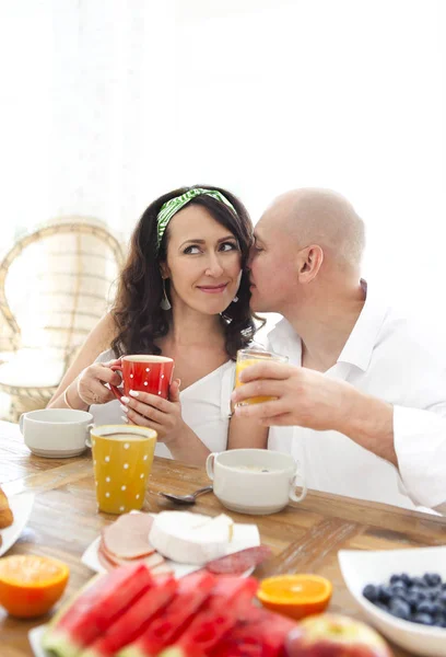 Liefdevol teder stel aan tafel met ontbijt — Stockfoto