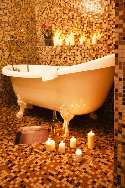 オレンジモザイクセラミックタイルの床と燃焼キャンドルで飾られた壁とバスルームでの高級ヴィンテージバスタブ — ストック写真