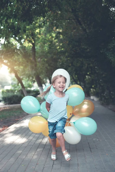 Ευτυχισμένο Κοριτσάκι Ένα Μάτσο Πολύχρωμα Μπαλόνια Που Τρέχουν Και Διασκεδάζουν — Φωτογραφία Αρχείου