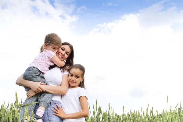 Pleased Young Mother Laughing Looking Camera Hugging Little Daughters Green — Stock Photo, Image