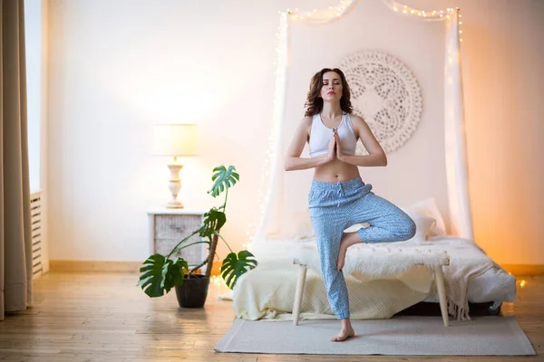 Gülen Kahverengi Saçlı Pijamalı Bir Kadın Parlak Yatak Odasında Yoga — Stok fotoğraf