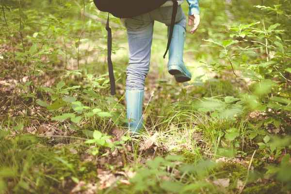 Nogi Kobiet Podróżujących Dżinsach Gumowych Butach Plecakiem Terenie Wysoką Zieloną — Zdjęcie stockowe