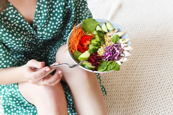 野菜や鶏の肉と健康的なサラダとボウルを示す緑のドレスで無名の裸足の女性のトップビュー 閉じろ — ストック写真