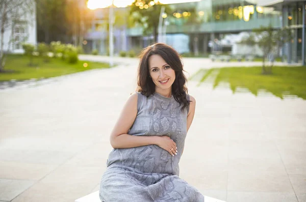Feliz Embarazada Tocando Vientre Suavemente Mientras Relaja Parque Durante Atardecer — Foto de Stock