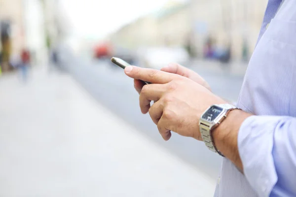 거리에서 스마트폰을 사용하는 파란색 셔츠와 손목시계를 착용하고 수컷의 — 스톡 사진