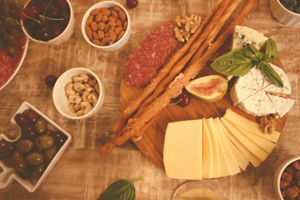 Holztisch Mit Weißwein Und Verschiedenen Leckeren Snacks Aus Käse Und — Stockfoto