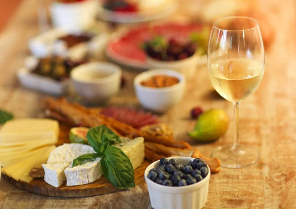 夕方にはリビングで白ワインとチーズとオリーブの各種おいしいスナックと木製のテーブルセット — ストック写真