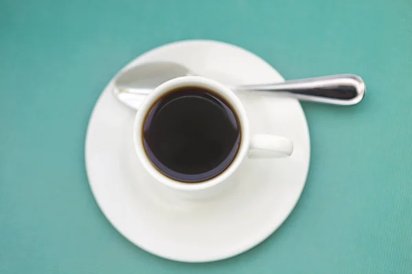 放在蓝色背景茶托上的新鲜浓缩咖啡和勺子的顶部视图 — 图库照片