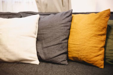 Oturma odasının içinde gri kanepe ve sarı yastıklar var. Samimi arkaplan