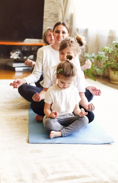 Yetişkin Kadınlar Küçük Kızlar Evde Yoga Yaparken Yerde Oturup Kollarını — Stok fotoğraf