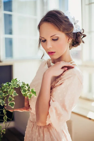 美丽的女人，穿着长裙持有房子植物. — 图库照片