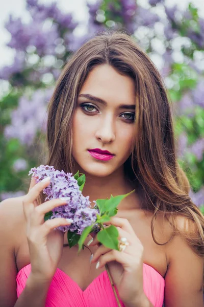 Portrait de jeune belle femme tenant une branche lilas — Photo
