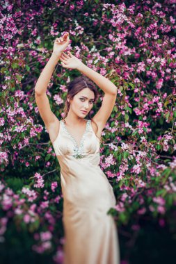 Bahar çiçeği ağaçlar arasında poz genç güzel kadın portresi.