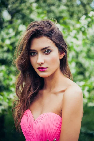 Retrato de jovem bela mulher posando entre árvores de maçã florescendo . — Fotografia de Stock