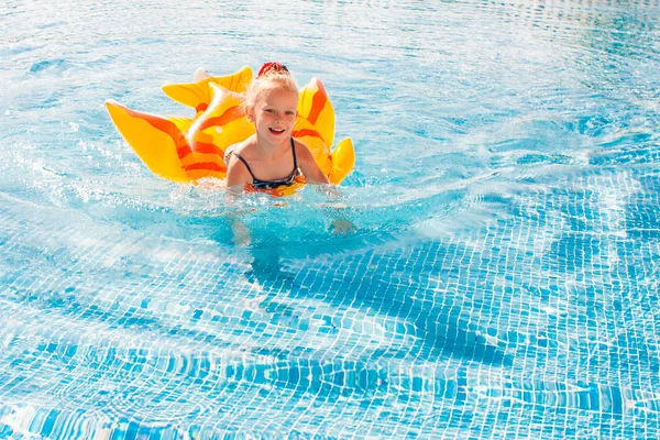 Linda niña feliz divirtiéndose en la piscina — Foto de Stock