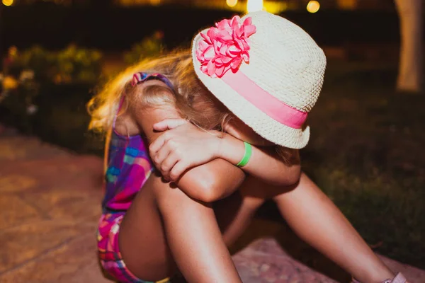 Porträtt av sorgliga blond liten flicka sitter på marken. — Stockfoto