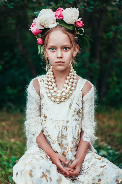 Porträtt av en liten flicka med blomsterkrans pion — Stockfoto