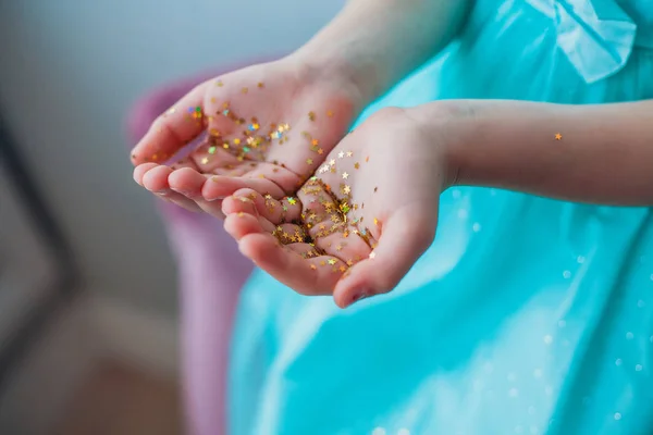 Маленькі дівчатка руки вкриті золотими блискучими зірками Стокове Зображення