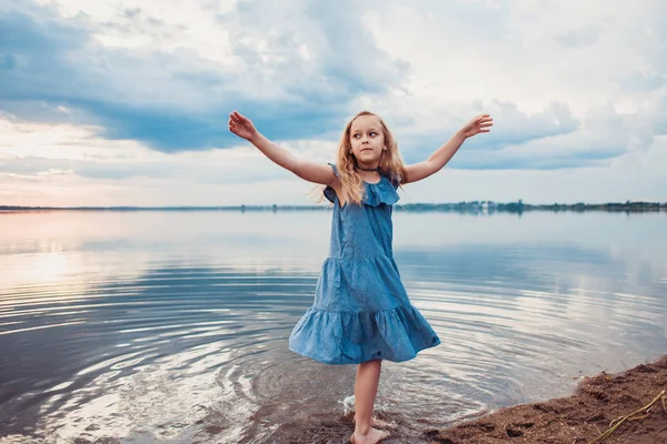 Sevimli küçük kız gölde eğleniyor.