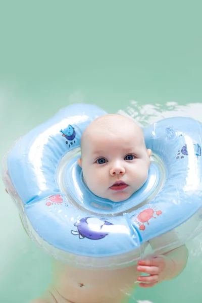 Neugeborenes Mädchen beim Baden mit Nacken-Gummiring. — Stockfoto