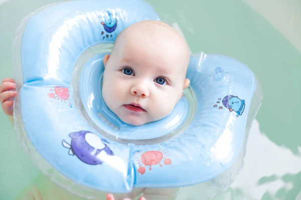 Banho da menina do bebê recém-nascido com anel de natação inflável . — Fotografia de Stock