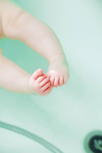 Close-up zdjęcie uroczych noworodka stóp w wodzie do kąpieli. — Zdjęcie stockowe