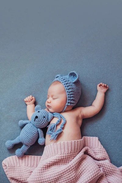 Linda niña recién nacida durmiendo con oso de peluche en manta gris . — Foto de Stock