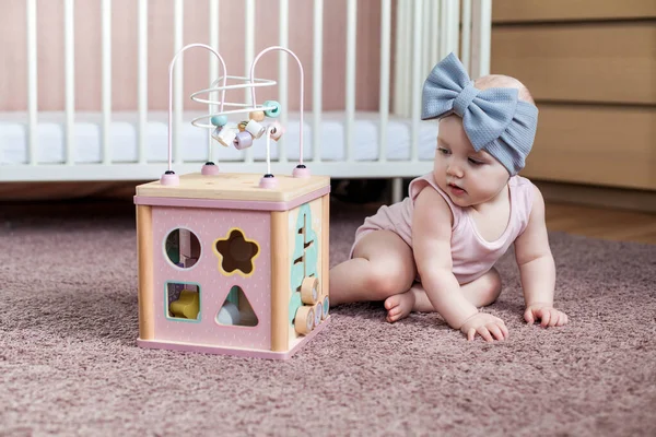 Cute baby girl gry z drewnianą zabawką aktywności. — Zdjęcie stockowe