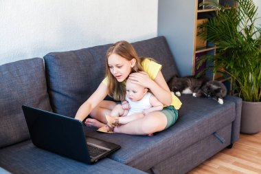 Kafkasyalı kız kardeşler görüntülü arama için dizüstü bilgisayar kullanarak sohbet ediyorlar..