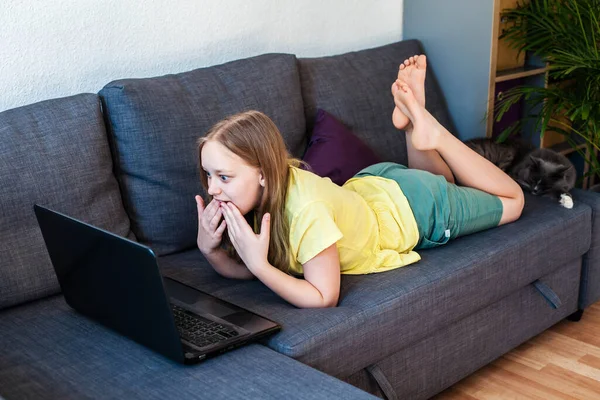 П'ятнадцять кавказька дівчина з здивованим виглядом спілкування онлайн за допомогою ноутбука для відеодзвінків . — стокове фото