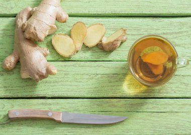  Ginger çayı ve malzemeler ahşap bir arka planda.