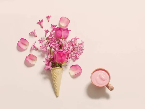 Fleurs dans un cône de gaufre avec du yaourt sur fond blanc — Photo