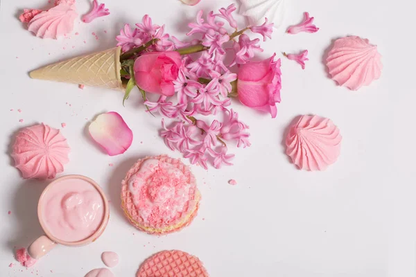 Fleurs dans un cône de gaufre avec yaourt et meringues sur le dos blanc — Photo