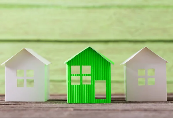 木製の緑の背景の紙の家 — ストック写真