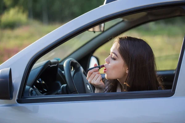 Meisje schildert haar lippen in de auto — Stockfoto