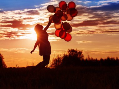 gün batımında Balonlu genç kadın