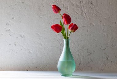 Vazoda beyaz zemin üzerine kırmızı tulops