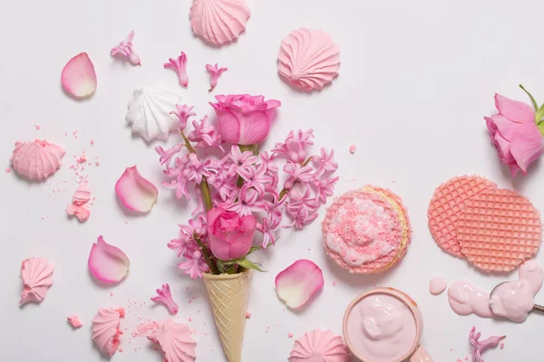 Fleurs dans un cône de gaufre avec yaourt et meringues sur le dos blanc — Photo