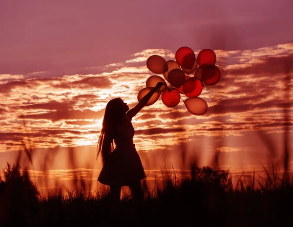 Jeunes femmes avec des ballons au coucher du soleil — Photo