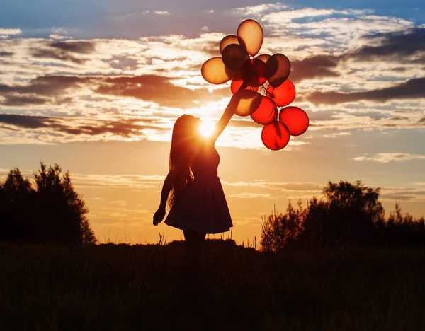 Молодые женщины с воздушными шарами на закате — стоковое фото