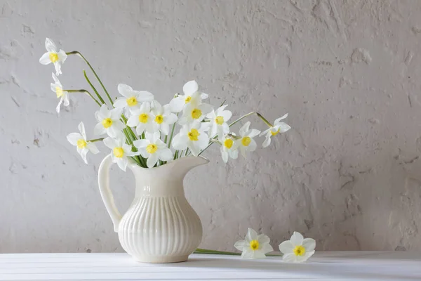 Narcisos en jarra sobre fondo blanco — Foto de Stock