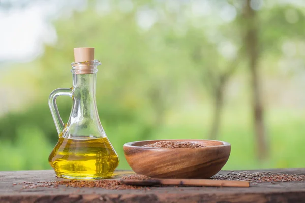 Leinsamen und Leinöl in einem Glaskrug auf einem Holztisch — Stockfoto
