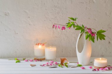 arka plan beyaz duvar mumlarıyla Vazoda Çiçekler