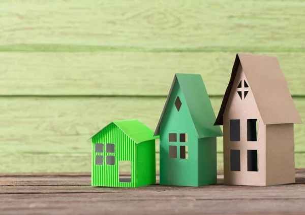 木製の緑の背景の紙の家 — ストック写真