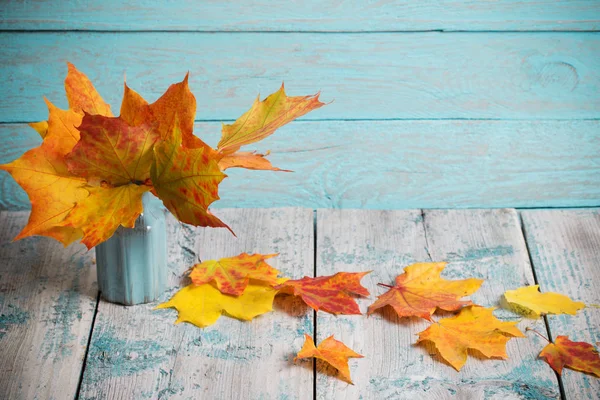 Maples in vase on wooden background — Stock Photo, Image