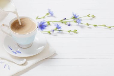 Hindiba beyaz tahta masada bir fincan içmek