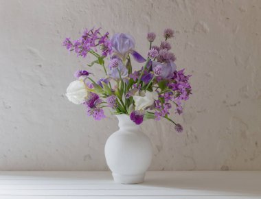 Vazodaki çiçekler arka plandaki beyaz duvarda