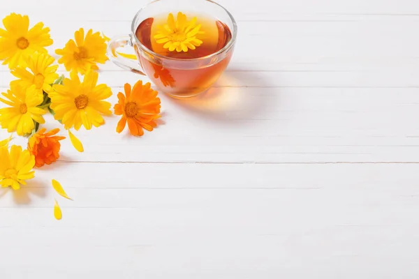 Beyaz ahşap masa Calendula (kadife çiçeği) bitkisel çay — Stok fotoğraf